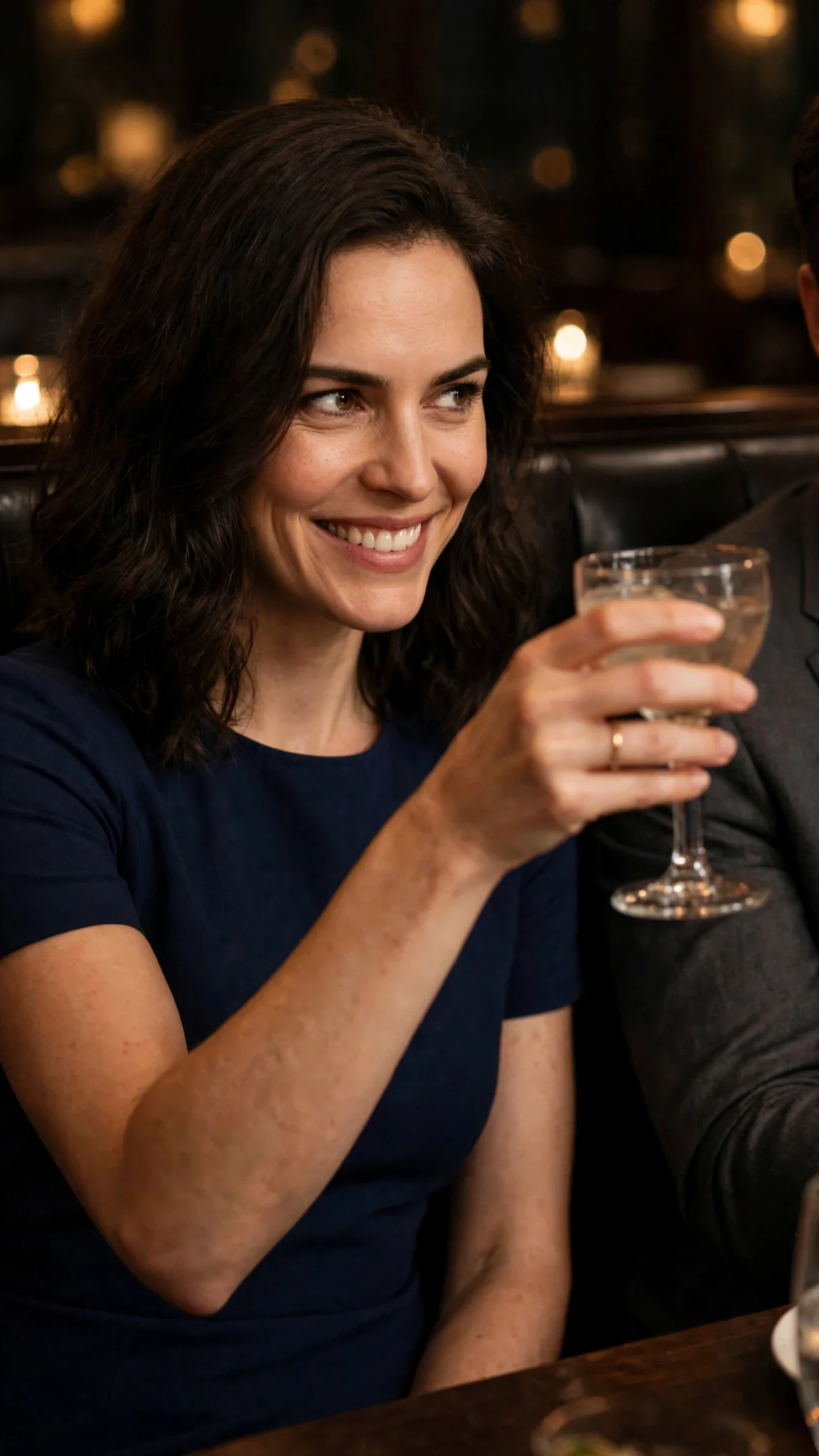Lena lifts her glass to Grant and smiles.