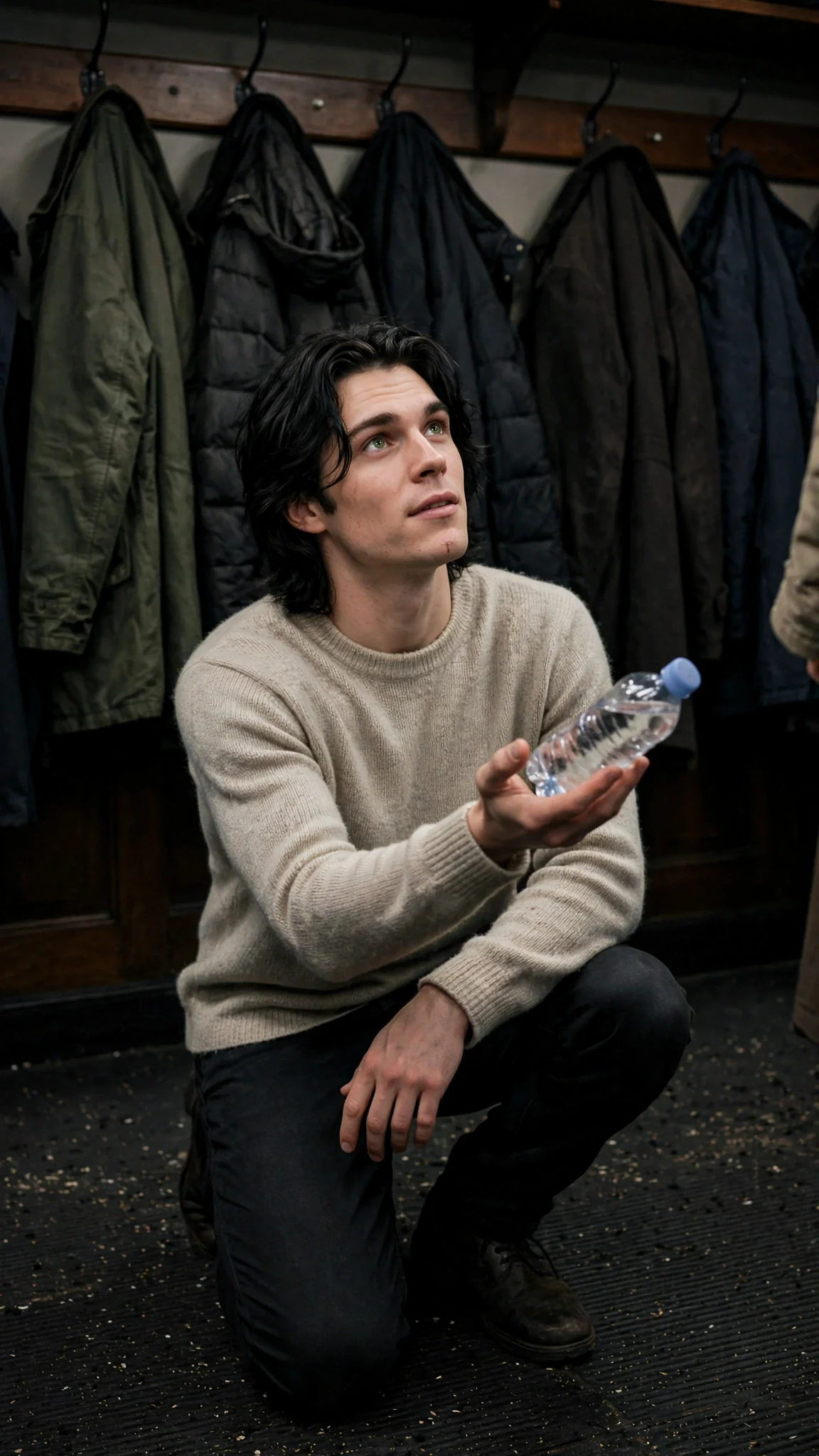 Finn kneels a few steps away and holds out the bottle, keeping his distance.