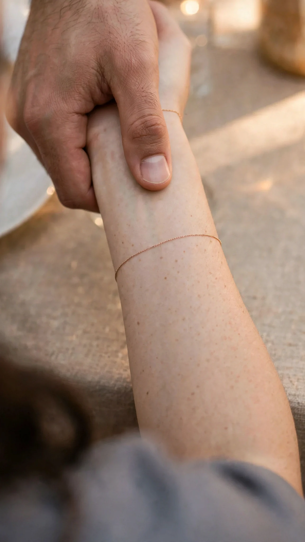 Extreme close-up of a man's thumb pressing a smooth bare wrist.